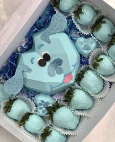 a box filled with blue and white chocolates covered in frosting