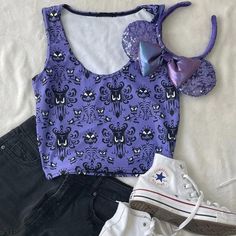 a pair of converse shoes and mickey mouse ears are sitting on a bed with purple tank top