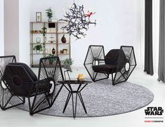 a living room with black chairs and a rug on the floor in front of it