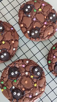 chocolate cookies decorated with eyes and stars on a cooling rack