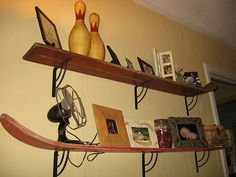 two wooden bowling pins sitting on top of a shelf next to pictures and other items