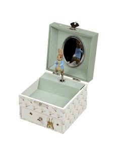 a small white box with an animal figurine in it's opening lid