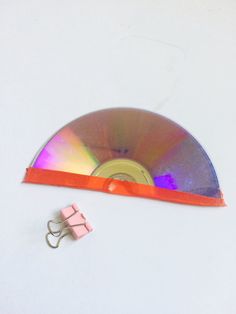 there is a small pink object next to a cd