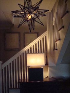 a star light hanging from the ceiling above a staircase