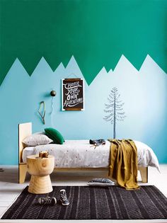 a bedroom with mountains painted on the wall and a bed in front of it,