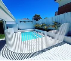 an empty swimming pool surrounded by white fencing