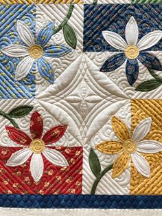 a quilted wall hanging with flowers on it