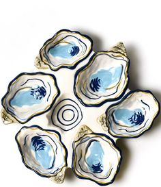 four blue and white dishes sitting on top of each other in the middle of a circle