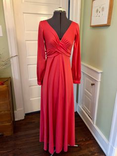 I didn't know Frederick's of Hollywood made anything besides lingerie! This long dress is made of 100% polyester knit fabric in a deep coral. It is unlined and does not have shoulder pads. It features a deep v neckline, and empire waist with large and long gathered ties that tie in back. It has long sleeves with snap cuffs, a flared skirt, and a back zipper closure with hook and eye. This garment is clean, with no stains, snags or odors. Measurements to guide you: Bust: 32" Waist: 28-30" Hip: 40-42" Sleeve: 24.5" (will blouse a little at cuff) Length from top of shoulder to hem: 55" Decade: 70s Fabric: Polyester Knit Size: S Condition: Great Brand: Frederick's of Hollywood, "Where Glamour is a way of life!" It's a delight to pick through time for you to find these vintage treasures. Fredericks Of Hollywood, Coral Red, Flared Skirt, Dress Clothes For Women, Flare Skirt, Empire Waist, Shoulder Pads, Halloween Shopping, Knit Fabric