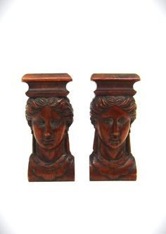 pair of carved wooden head vases on white background