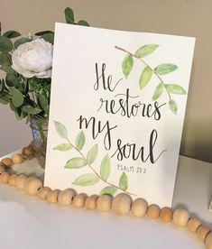 a card that says he restores my soul on it next to a vase with flowers