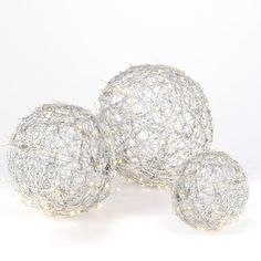 three silver balls with white lights on them