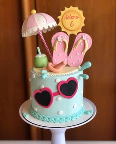 a birthday cake decorated with flip flops, sandals and an umbrella for someone's 6th birthday