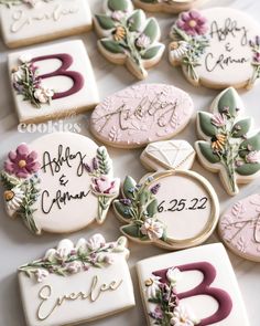 decorated cookies with names and flowers are on a white tablecloth for a wedding or bridal party