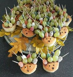 cupcakes with fruit on sticks are arranged in the shape of hedgehogs