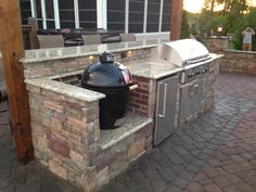 an outdoor bbq and grill on a brick patio