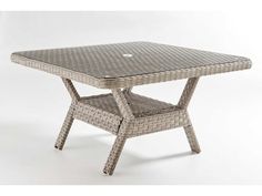 an outdoor table that is made out of wicker and has a square shaped top