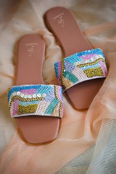 "Introducing the Mojabella Handcrafted Slider Sandal in the laid-back and stylish \"Laid Back\" design. These sandals are perfect for your summer adventures, featuring a beautiful rose pink sole adorned with intricate sequin, bead, and brass work embroidered on a padded strap. The attention to detail in the design of these sandals is truly remarkable, showcasing exquisite craftsmanship and a stunning array of colors. The combination of sequins, beads, and brass work creates a captivating and uni Multicolor Open Toe Fabric Sandals, Fancy Sandals, Rolled Jeans, Comfortable Chic, Slider Sandals, Beads Bracelet Design, Satin Bags, Stylish Sandals, Slingbacks