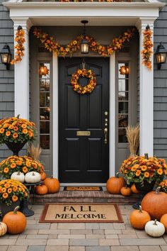 a front door decorated for fall with pumpkins and flowers