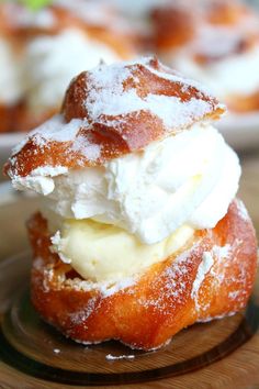 two donuts covered in powdered sugar and whipped cream