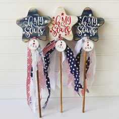 three wooden stars with red, white and blue ribbons attached to them