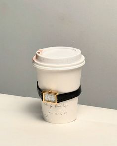 a white coffee cup with a black band around it