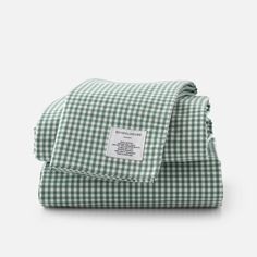 the green and white gingham checkered sheets are folded on top of each other