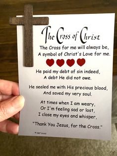 a hand holding up a paper with a cross on it and the words, the cross of christ