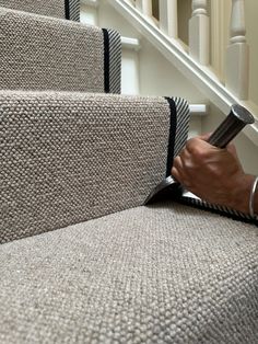 a person is using a brush to clean the carpet on some stair treads at the bottom of stairs