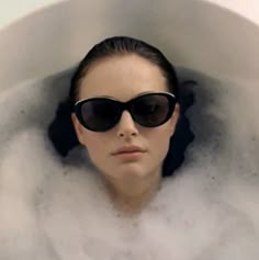 a woman wearing sunglasses in a bubble bath