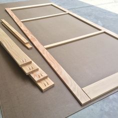 some wood pieces are laying on the floor next to an unfinished frame and window pane