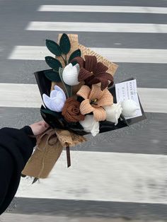 a person holding a bunch of flowers on the street