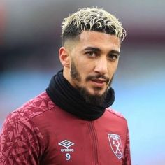 a close up of a soccer player with a goatee on his head and wearing a scarf