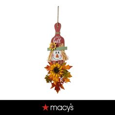 a christmas ornament with a scarecrow and sunflowers hanging from it's side