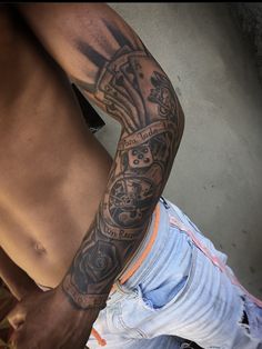 a man's arm with tattoos on it and his jeans rolled up to the side