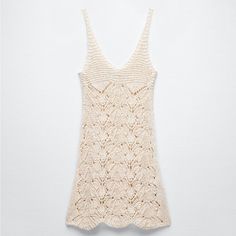 a crocheted tank top hanging on a wall