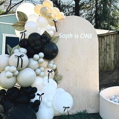 balloons are arranged in front of a gravestone with the words soph is one on it