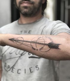 a man with a tattoo on his arm holding an arrow