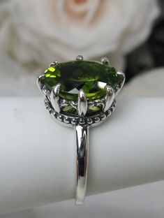 5ct Natural Peridot Ring Setting Description #223 Made To Order Inspired by Victorian designs I now offer this Antique reproduction in sterling silver. This gorgeous ring is set with an oval 5ct Natural Peridot. The approximately 5ct faceted gemstone is 12mm x 10mm in dimension. The inside of the band is marked 925 for sterling. Notice the beautiful crown filigree swirl like the craftsmanship of the silver setting. This is an exquisite rendition of an antique filigree ring and an amazing deal. F Green Solitaire Crystal Ring, Peridot Crystal Ring For Anniversary, Classic Green Crystal Ring, Green Ring With Large Stone, Solitaire Peridot Ring, Round Peridot Solitaire Ring, Round Solitaire Peridot Ring, Formal Peridot Rings With Polished Finish, Green Peridot Bohemian Jewelry