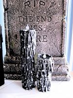 three black and white vases sitting next to a headstone