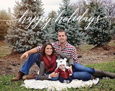 a man and woman sitting on a blanket in front of trees