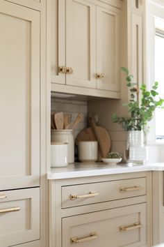 a kitchen with white cabinets and wooden utensils