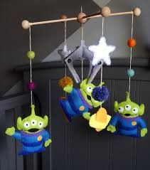 three toy mobiles hanging from the ceiling in a child's room with stars and aliens on them