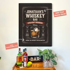 a wooden table topped with bottles and glasses next to a sign that says jonathan's whiskey bar