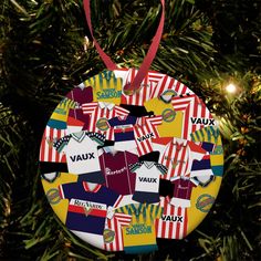 a christmas ornament hanging from a tree with soccer jerseys on it's side