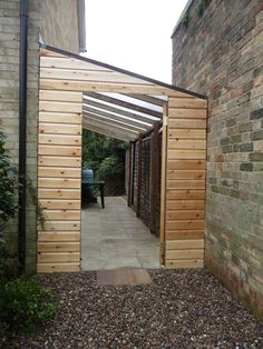 an open wooden door on the side of a brick building next to a stone walkway