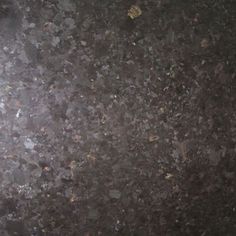 a close up view of the surface of a black granite counter top with yellow and white dots on it