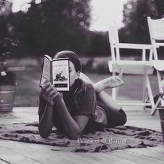 a woman sitting on the ground reading a book