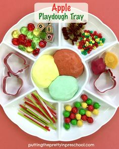 an apple playdough tray is shown with candy and candies on the plate