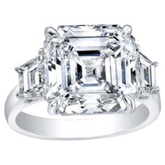 Elevate your love story with the timeless elegance of this GIA Certified 4.01 Carat Asscher Cut Diamond Engagement Ring, adorned with two trapezoid-cut diamonds on each side, all set in 18K gold. The centerpiece of this exquisite ring is a dazzling 4.01-carat Asscher cut diamond, certified by GIA for its exceptional quality and beauty. Renowned for its geometric precision and mesmerizing brilliance, the Asscher cut diamond exudes sophistication and vintage charm, making it a perfect choice for an engagement ring. Flanking the center diamond are two trapezoid-cut diamonds, meticulously chosen to complement the Asscher cut's elegance and add a touch of contemporary flair to the design. Together, they form a harmonious trio, symbolizing the past, present, and future of your love story. Set in Asscher Cut Engagement Ring, Asscher Cut Diamond Engagement Ring, 18k Gold Engagement Ring, Radiant Cut Diamond Ring, Asscher Cut Engagement Rings, Brilliant Cut Diamond Ring, Emerald Cut Diamond Engagement Ring, Contemporary Engagement Rings, Emerald Cut Diamond Ring